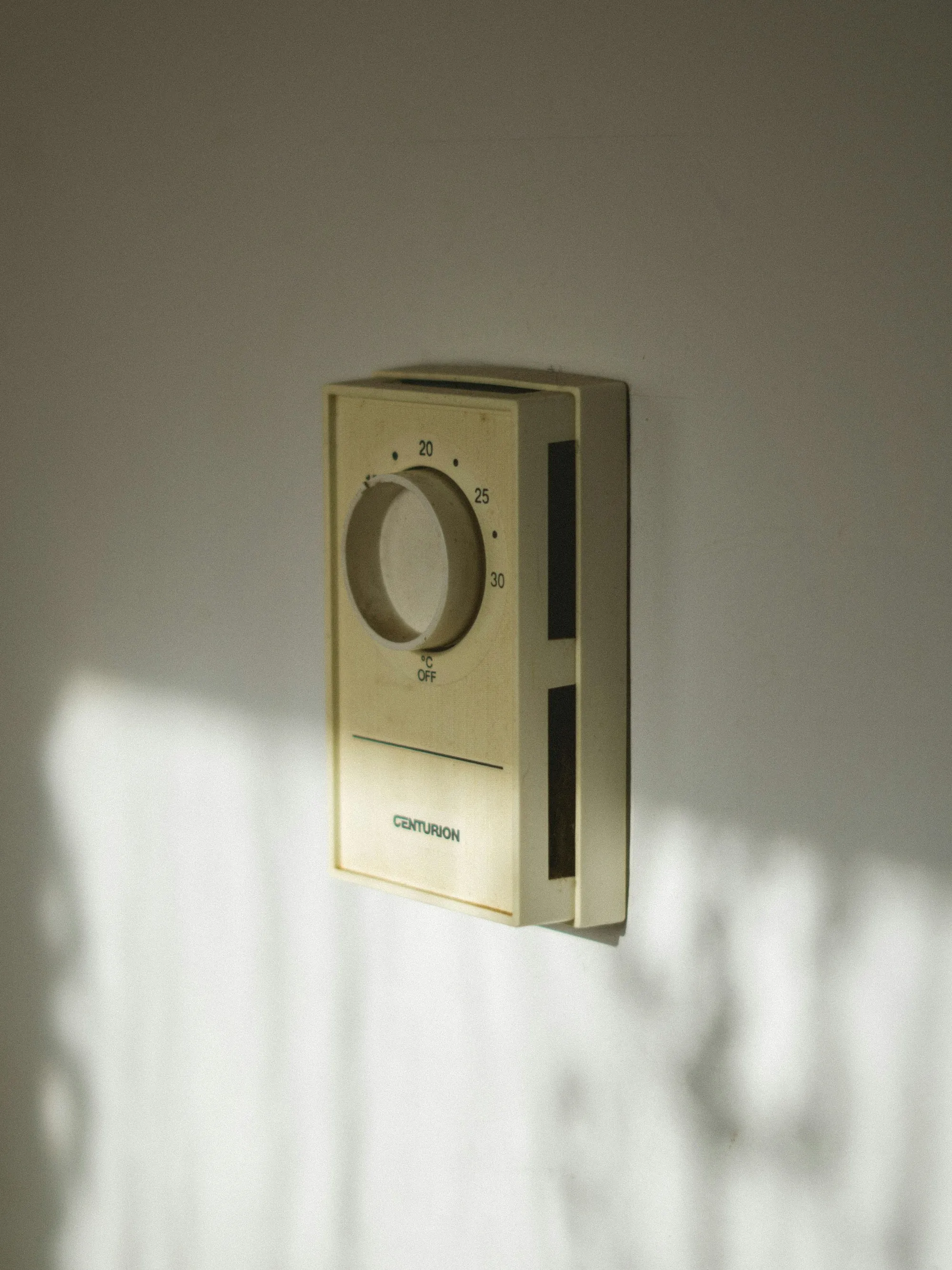Classic beige dial thermostat lit by sunlight